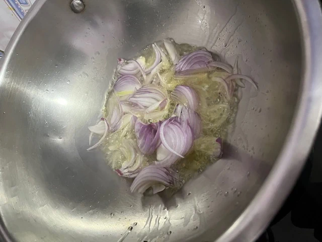 Once the ghee is hot, add the sliced onions