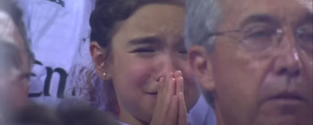 Young sports or football fan praying for the victory of his favorite club, Real Madrid.