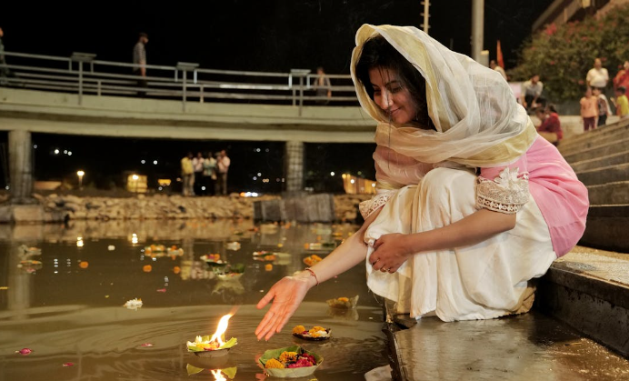 Girl performing pooja near the Ganga ghat.